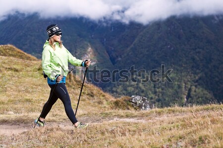 Woman hiker nordic walking in mountains Stock photo © blasbike