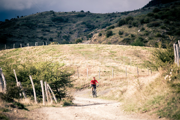 Mountain bike MTB rider on country road, track trail in inspirat Stock photo © blasbike