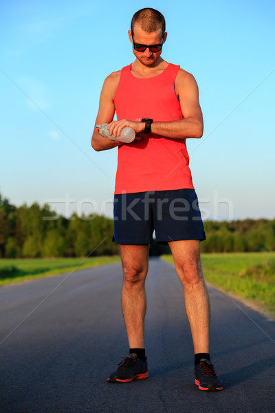 Runner training and checking stopwatch smart watch, cross countr Stock photo © blasbike