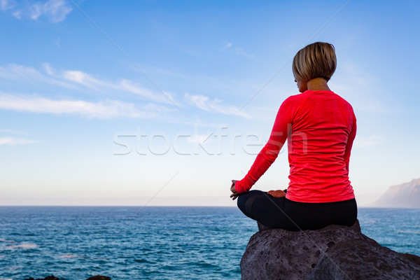 Woman meditating in yoga pose, ocean view Stock photo © blasbike