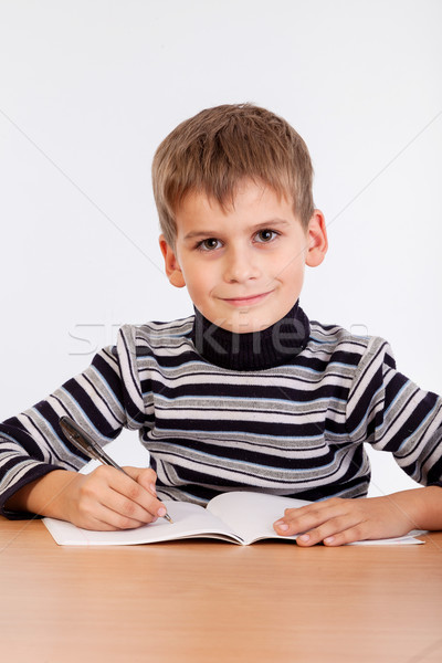 Cute schoolboy is writting Stock photo © bloodua