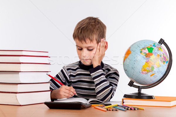 Cute schoolboy is writting Stock photo © bloodua