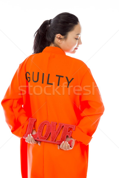 Rear view of a Asian young woman holding a red 'LOVE' text in prisoners uniform Stock photo © bmonteny