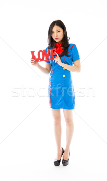 Disappointed Asian air stewardess holding red 'LOVE' text Stock photo © bmonteny