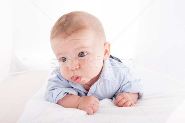 Baby boy lying on the bed and sticking his tongue out Stock photo © bmonteny