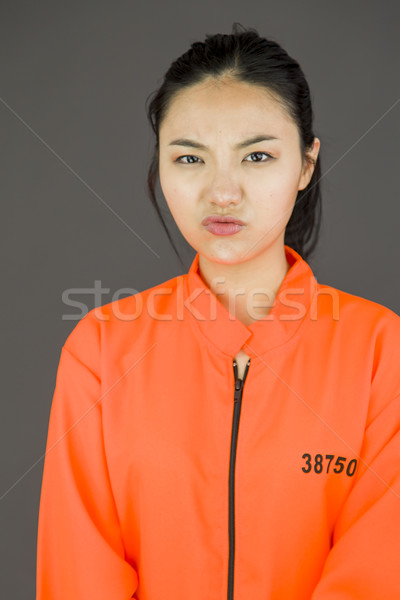 Upset young Asian woman in prisoners uniform Stock photo © bmonteny