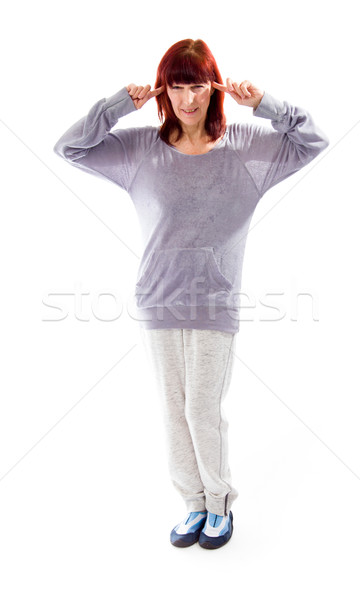 Mature woman standing with fingers in her ears Stock photo © bmonteny