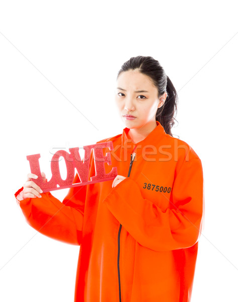 Asian young woman holding a red 'LOVE' text in prisoners uniform Stock photo © bmonteny