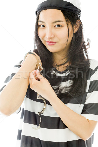 Asian young woman in prisoners uniform opening handcuffs Stock photo © bmonteny