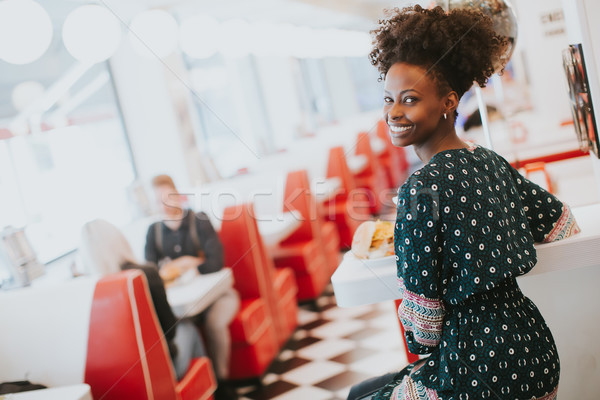 Young african american woman eating in the diner Stock photo © boggy