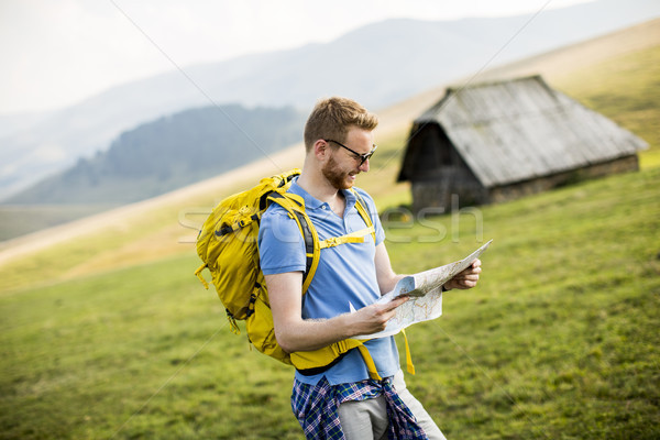Young redhair man on mountain hiking holding a map Stock photo © boggy