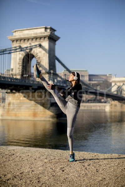Woman in sportswear stretching on Danube river promenade in Buda Stock photo © boggy