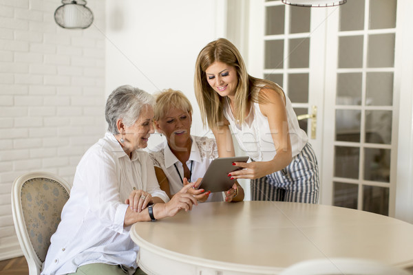 Three female generation looking on digital tablet Stock photo © boggy