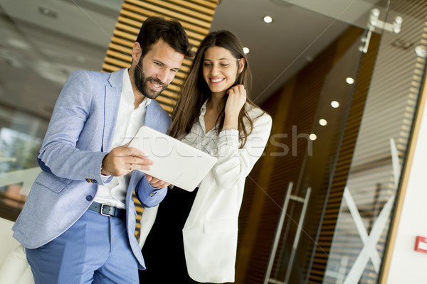 Stock photo: Handsome young couple with tablet in the modern office