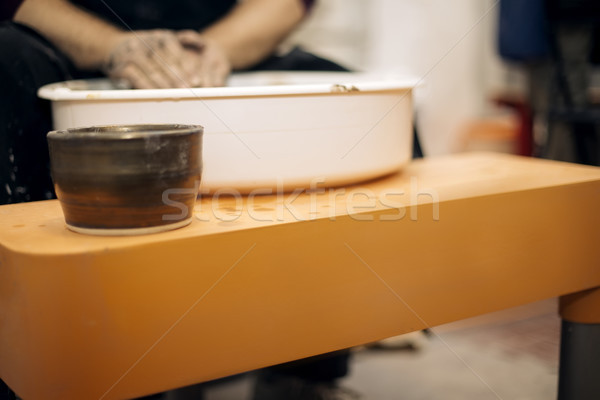 Stock photo: Male artist makes clay pottery on a spin wheel