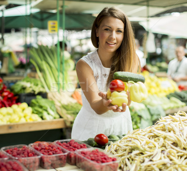 Young woman picking fresh vegetable at the market Stock photo © boggy