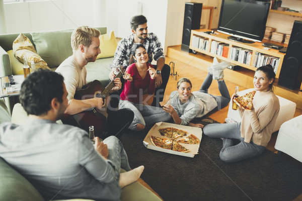 Young people eating pizza and drinking cider in the room Stock photo © boggy