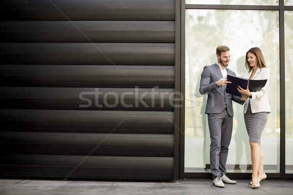 Young business people talking and viewing documents outdoor Stock photo © boggy