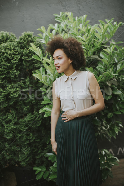 Curly hair young woman standing in the courtyard Stock photo © boggy