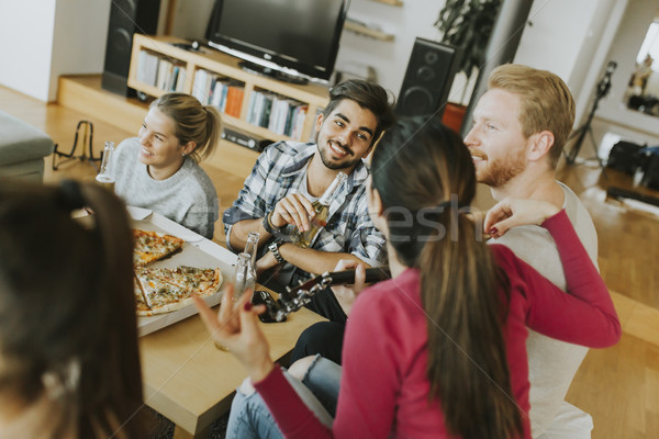 Young people having pizza party in the room Stock photo © boggy