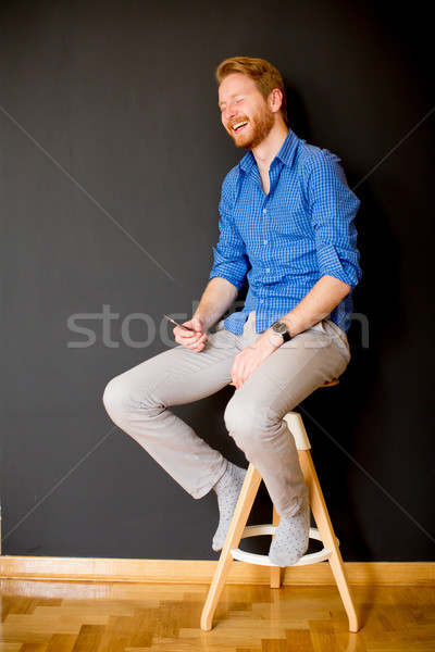 Redhair man with mobile phone by wall Stock photo © boggy