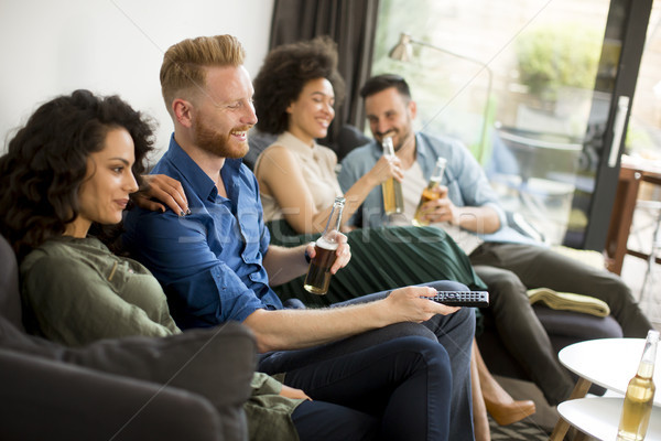 Group of friends watching TV, drinking cider and having fun Stock photo © boggy