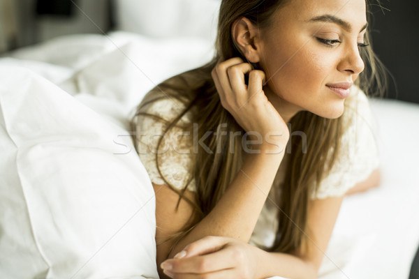 Young woman relaxing in white bed after waking up Stock photo © boggy