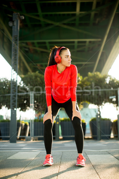 Young attractive female  runner taking break after jogging outdo Stock photo © boggy