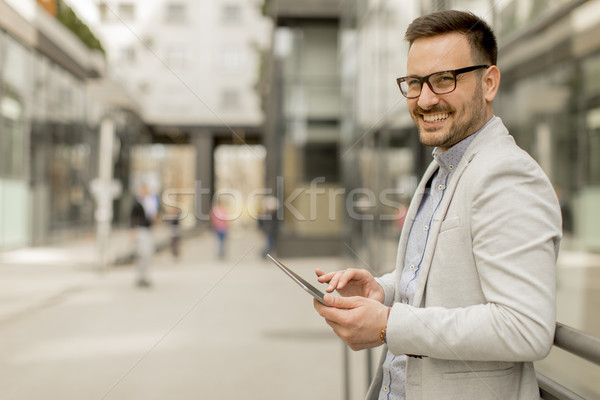 Jungen Geschäftsmann digitalen Tablet Bürogebäude gut aussehend Stock foto © boggy