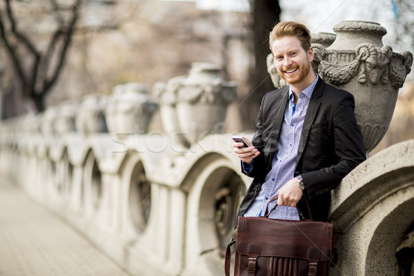 имбирь бизнесмен ждет транспорт мобильных мобильного телефона Сток-фото © boggy