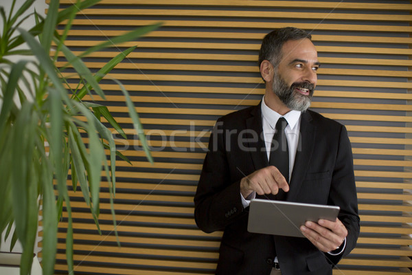 Middle age businessman with tablet in the office Stock photo © boggy