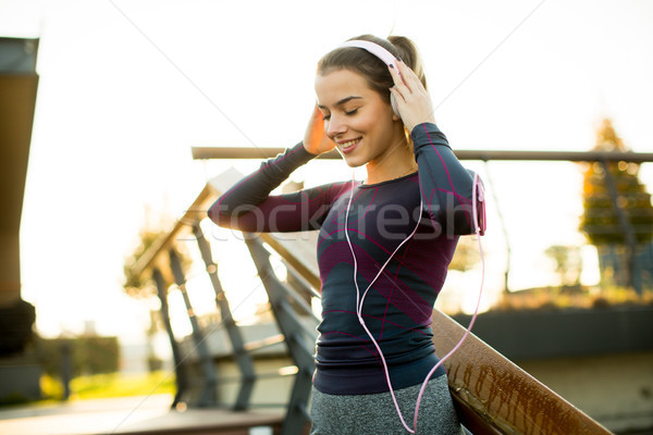 Young attractive female  runner taking break after jogging outdo Stock photo © boggy