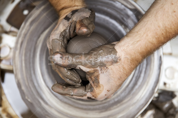 Artist makes clay pottery on a spin wheel Stock photo © boggy