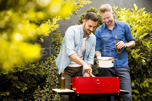 Two young men preparing  barbecue in the courtyard Stock photo © boggy