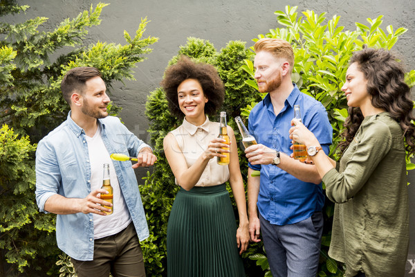 Young smiling people stand outside and toast with cider in the h Stock photo © boggy