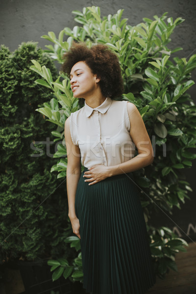 Curly hair young woman standing in the courtyard Stock photo © boggy