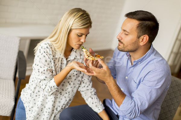 Couple relaxing at home and eating tasteful pizza Stock photo © boggy