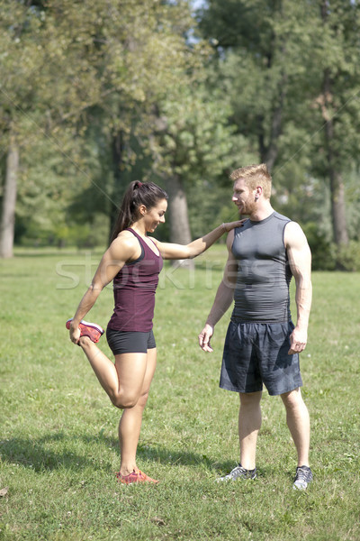 Woman doing stretching exercises with personal trainer in park Stock photo © boggy