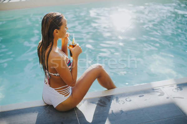 Young woman by the swimming pool with coctail Stock photo © boggy