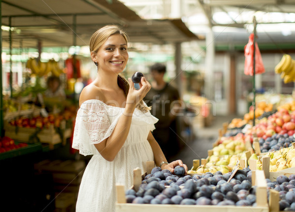 Young woman buying plums on the market Stock photo © boggy
