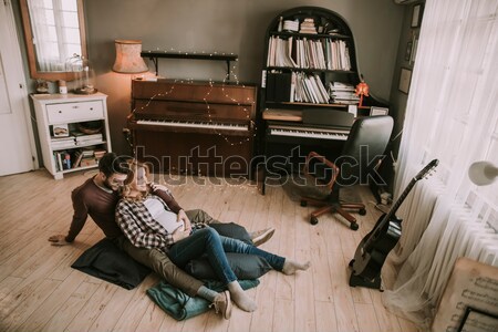 Father teaching daughter to play guitar at home Stock photo © boggy