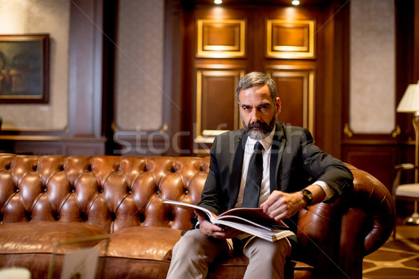 Handsome middle-aged businessman reading book Stock photo © boggy