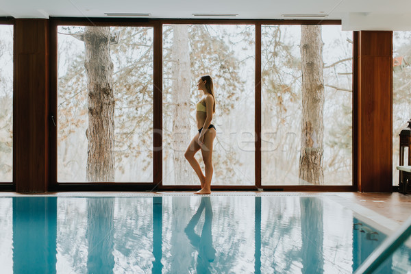 Young woman standing by the swimming pool Stock photo © boggy