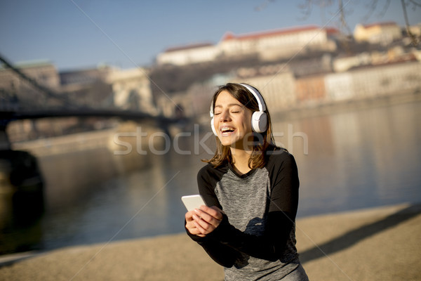 Woman making a pause after the exercise and using mobile phone Stock photo © boggy