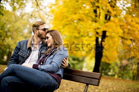 Women sitting on bench a park and watch something on a mobile ph Stock photo © boggy