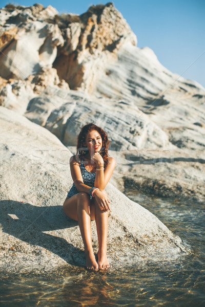 Pretty yung woman on the stony seaside beach Stock photo © boggy