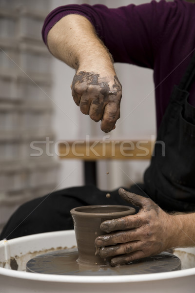 Artist makes clay pottery on a spin wheel Stock photo © boggy