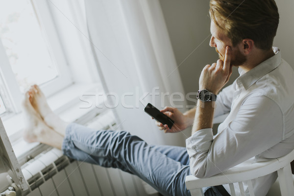 Handsome redhair man writes a message on the phone Stock photo © boggy