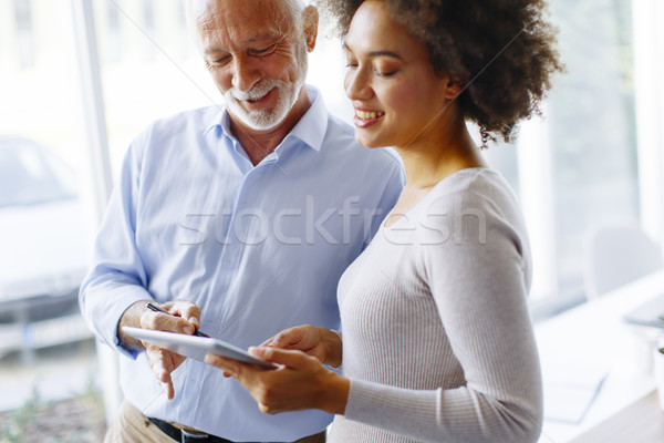 Stock photo: Senior businessman and young african american businesswoman with