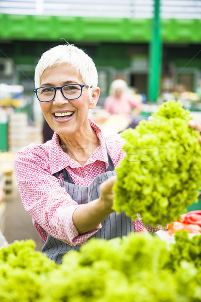 Senior woman sells lettuce on marketplace Stock photo © boggy